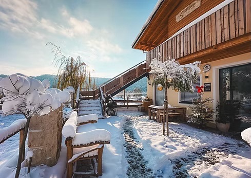 Verschneiter Außenbereich und Biergarten des Juraquell Fischbistros im Winter.